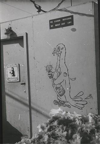 Фотография. Рисунок на одном из хилых домов летчиков американской научно-исследовательской базы Мак-Мердо. На рисунке надпись «Мы смеемся, потому что мы не можем плакать».