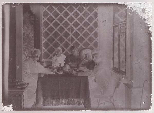 Негатив фотографии. Портрет групповой трех женщин и двух мужчин за столом на летней веранде.