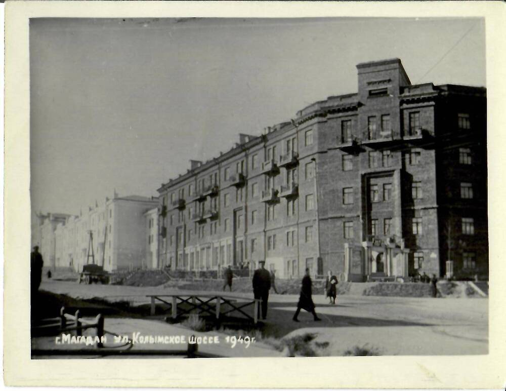 Фотография черно-белая, глянцевая печать. На фото: вид на пятиэтажное здание. В нижней части фото слева надпись: «г. Магадан, ул. Колымское шоссе 1949 г.», г. Магадан, 1940-1950-е гг.