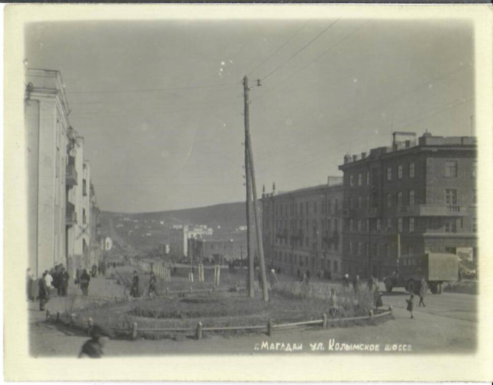 Фотография черно-белая, глянцевая печать. На фото: вид на улицу Колымское шоссе. В нижней части фото справа надпись: «г. Магадан, ул. Колымское шоссе», г. Магадан, 1940-1950-е гг.