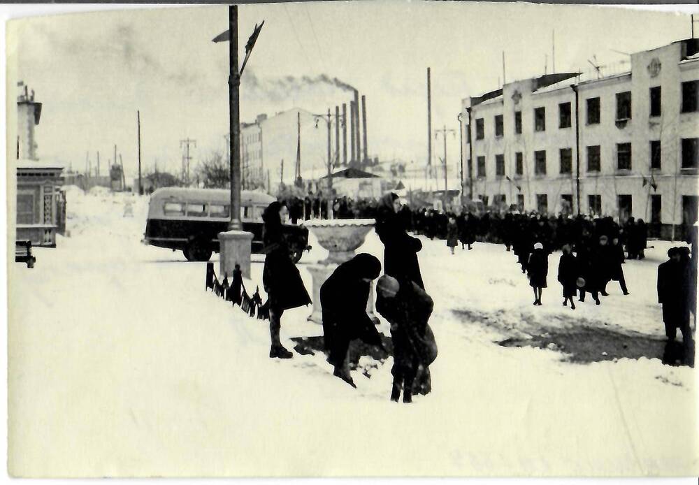 Фотография черно-белая, полуглянцевая печать. На фото: группы людей собираются в колонну для шествия на первомайской демонстрации. г. Магадан, 1961 г.
