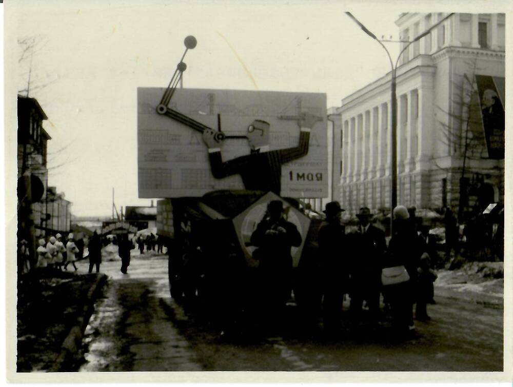 Фотография черно-белая, глянцевая печать. На фото: группа людей на первомайской демонстрации. На обороте машинописный текст: «Эмблема ГПИ «Дальстройпроект» на 1-е Мая… г. Магадан – 1.У.67г.», г. Магадан, 1967 г.