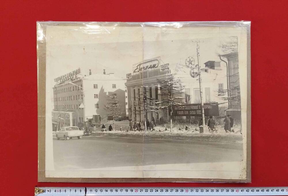 Фотография, черно-белая, глянцевая печать. На фото: вид на «Универсальный магазин» и кинотеатр «Горняк» на проспекте Ленина, г. Магадан,  1960-е гг.