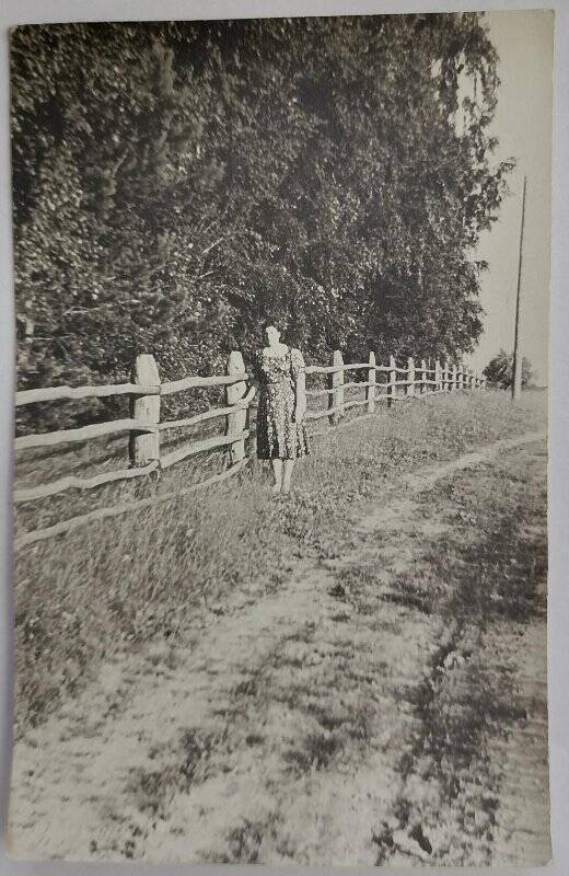 Фотография. Е.П. Танеева стоит рядом с деревянной изгородью.