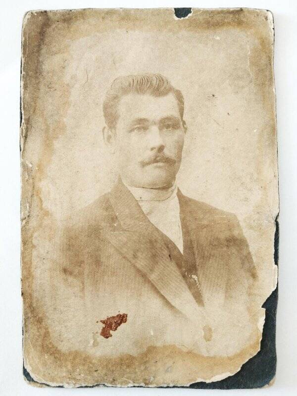 Фотография черно-белая (мужчина погрудно) на картонном паспарту. с фирменным оформлением «А.Косаревъ, Верхнеудинск».