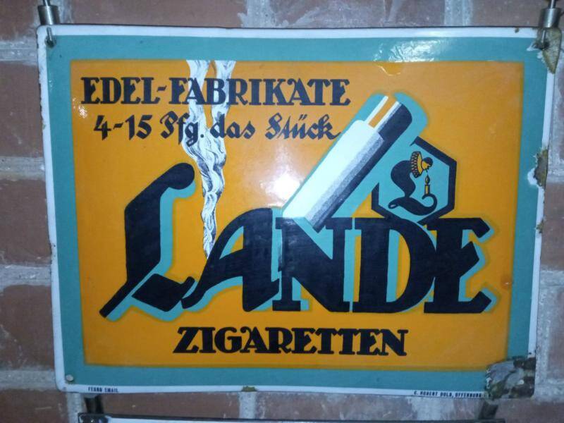 Табличка эмалированная цветная с надписью Edel-Fabrikate 4-15 Pfg. das Stuck.Lange Zigaretten. Предприятие изготовитель табличек - Ferro Email. C. Robert Dold, Offenburg