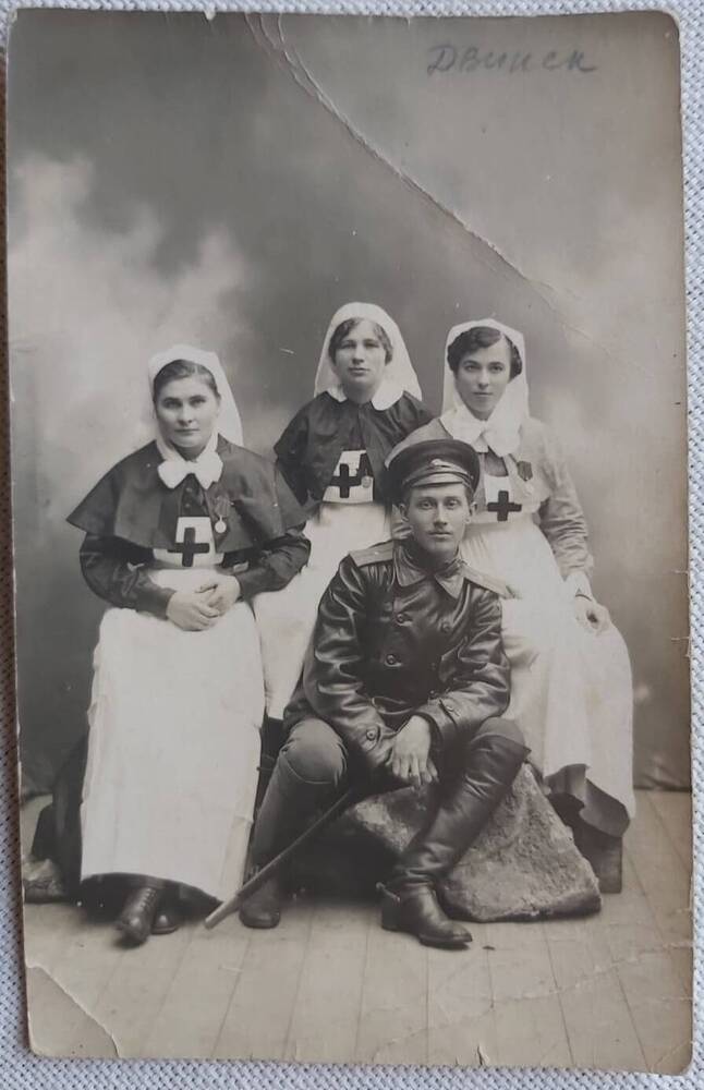 Открытка почтовая с фотографией трех сестер милосердия с мужчиной.