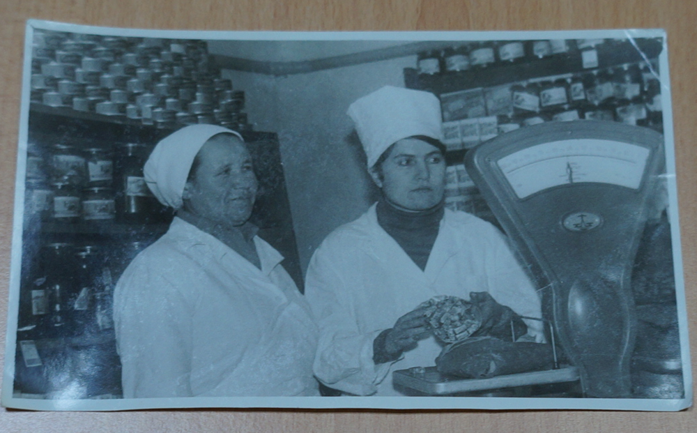 Фотография черно-белая с изображением сотрудников в дежурном магазине.