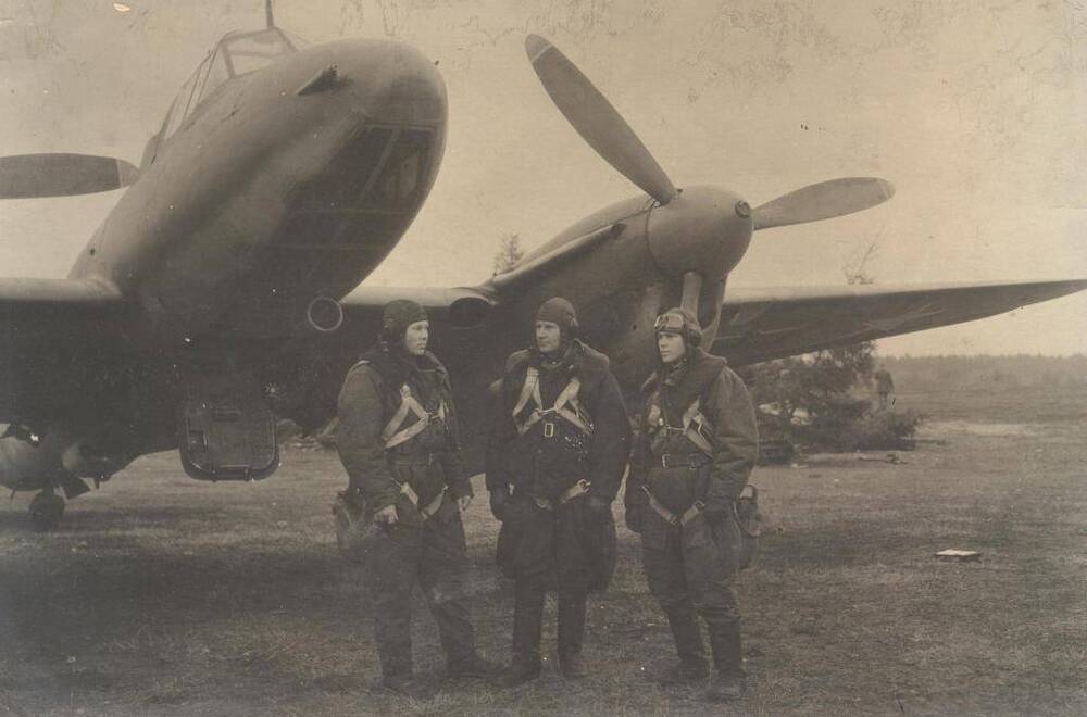 Портрет групповой: Первый боевой вылет на территорию Германии. Стоят три летчика на фоне самолета, среди них Туник Д.И. 1943 год.