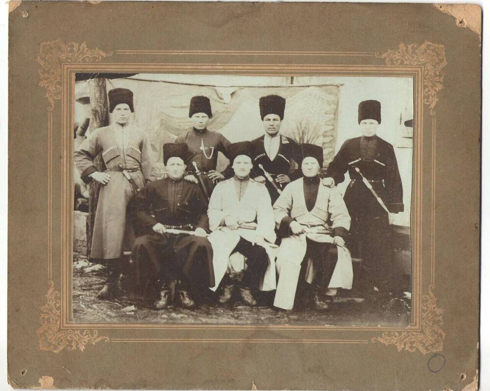 Казаки. Фотография чёрно-белая, групповая, на паспарту, с изображением 7-ми человек, мужчин, в казачьей форме, с оружием, расположенных в 2 ряда.