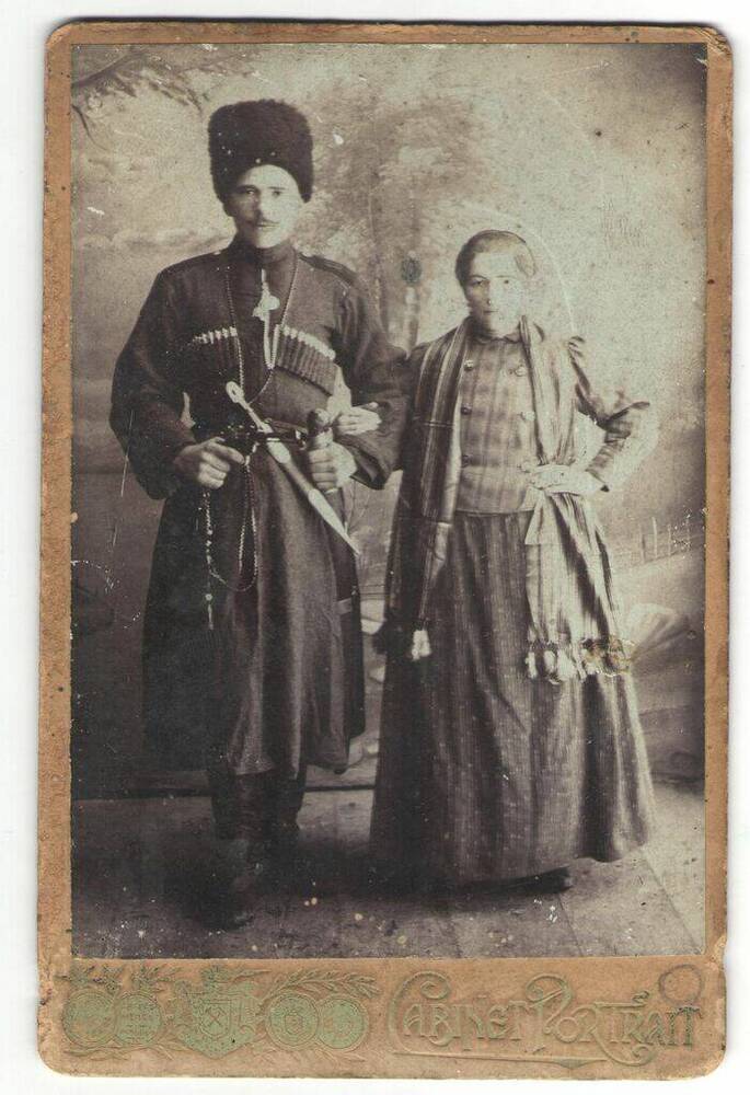 Казаки. Фотография чёрно-белая, на паспарту, с изображением 2-х человек (мужчины и женщины) в парадной /праздничной казачьей одежде.