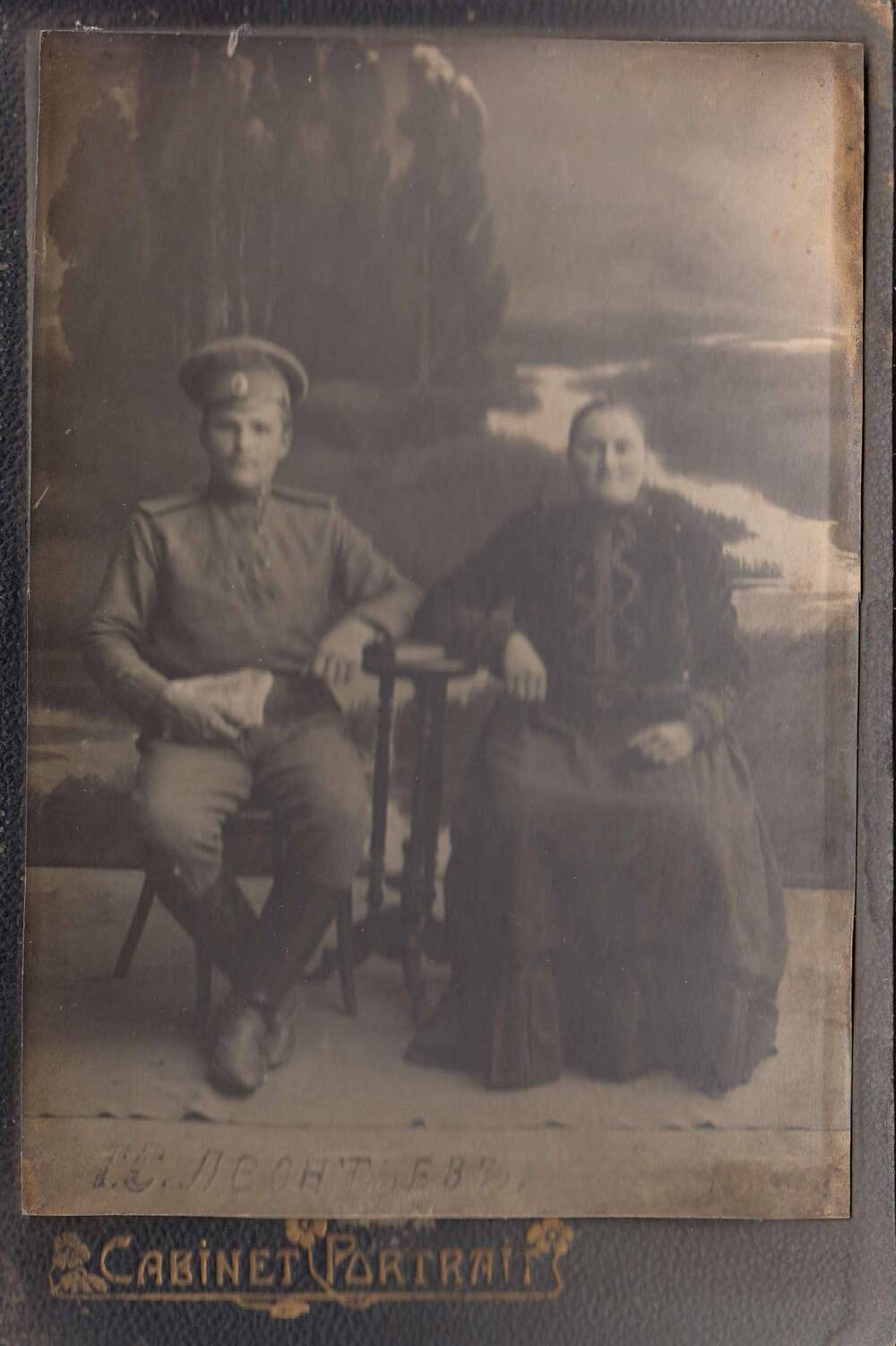 Фотография чернобелая изображением мужчины и женщины средних лет, сидящих на стульях.