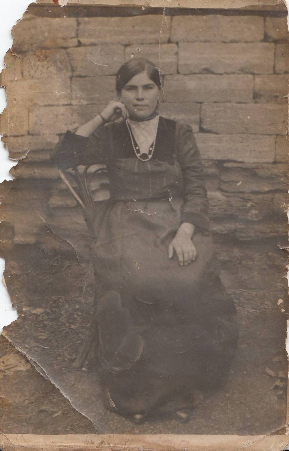 Фотография чернобелая с изображением портрета женщины, сидящей на стуле .