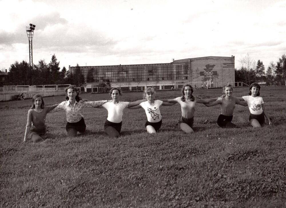 Фото ч/б документальное. На снимке, на траве стадиона порта Ванино возле Дворца Спорта идут занятия по гимнастике. 