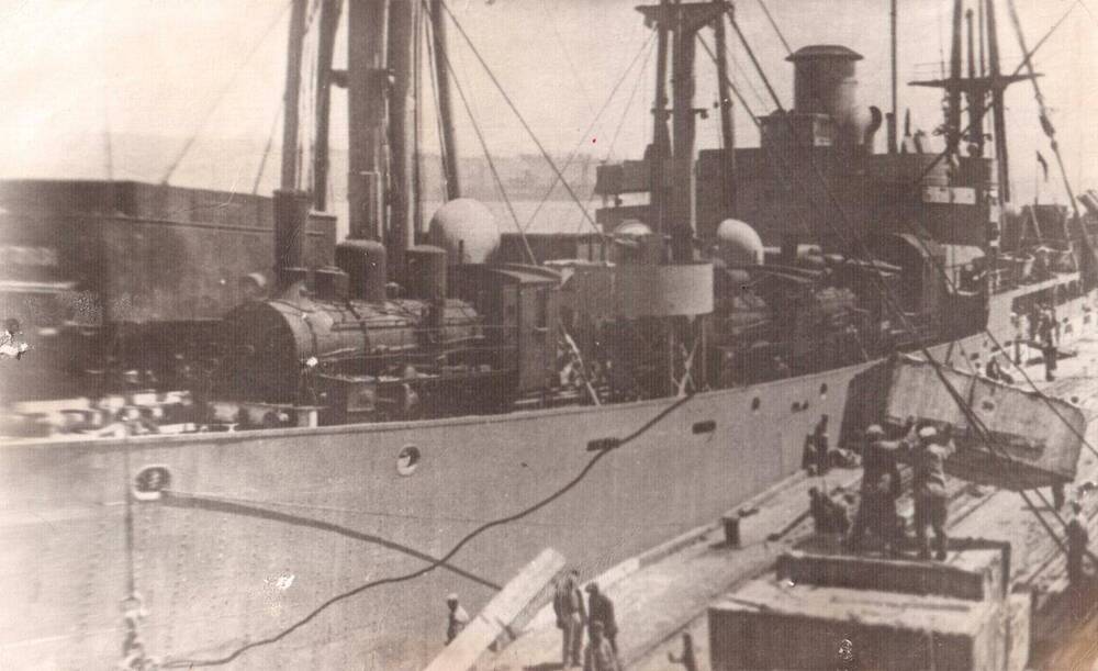 Фото ч/б документальное. На снимке у пирса идет выгрузка с судна прибывшего в порт Ванино с паравозами 1945 года.