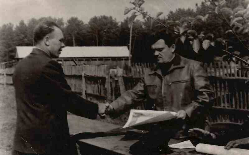 Фото черно-белое. Михаил Иванович Егоров (справа) вручает Почетную грамоту работнику лесхоза.