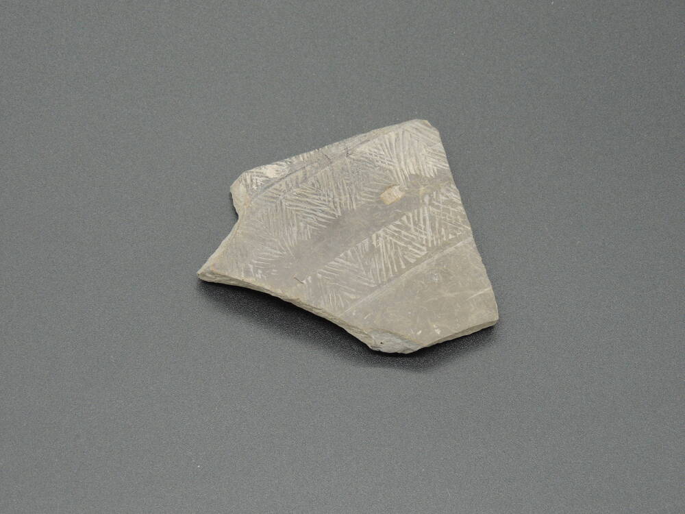 Фрагмент керамики с орнаментом в виде полосок елочка.