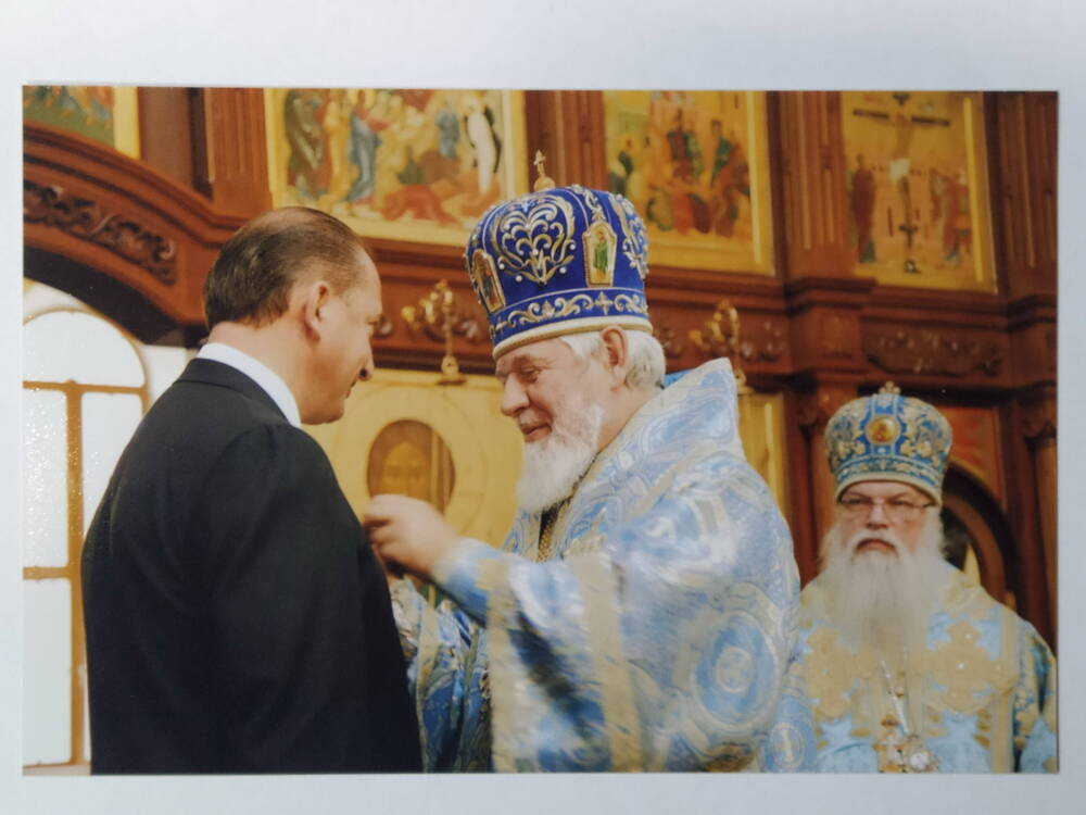 Фото. Архиепископ Сергий вручает В.В.Артякову памятный знак.
