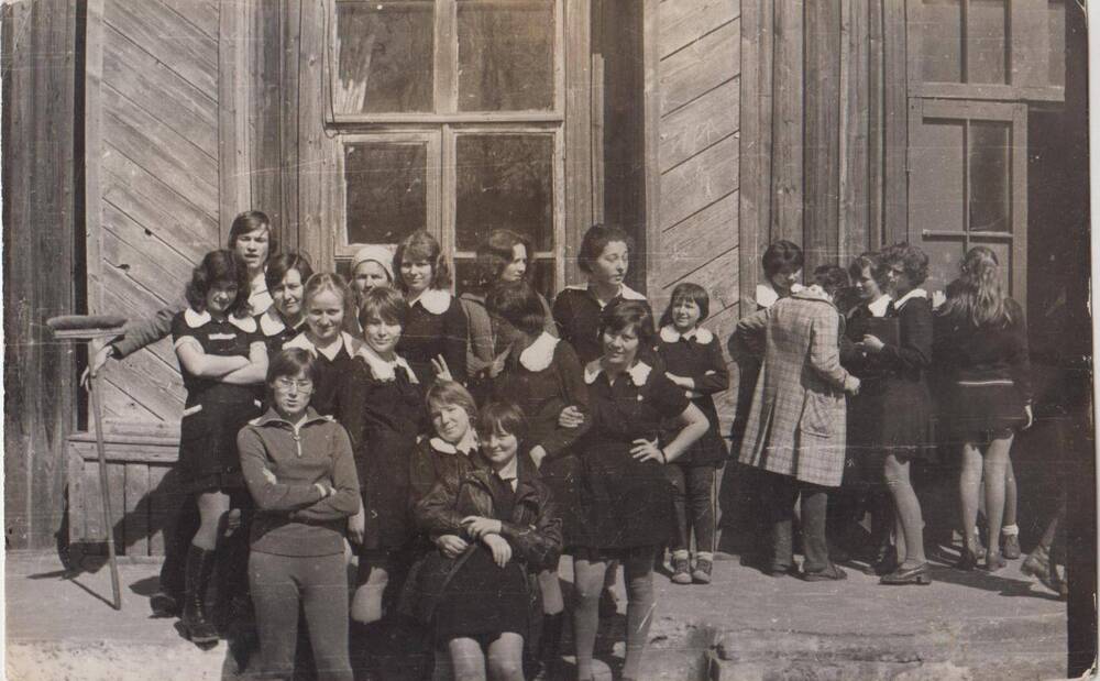 Фотография чёрно-белая групповая. Учащиеся Ромненской школы на фоне здания школы.