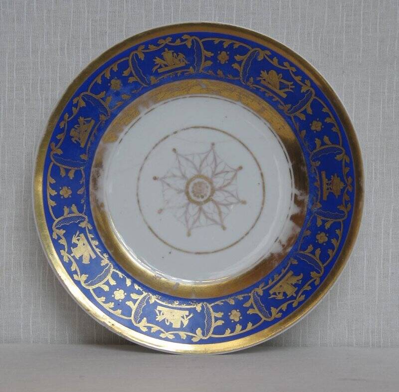 Тарелка с синим бортом с золоченым орнаментом.