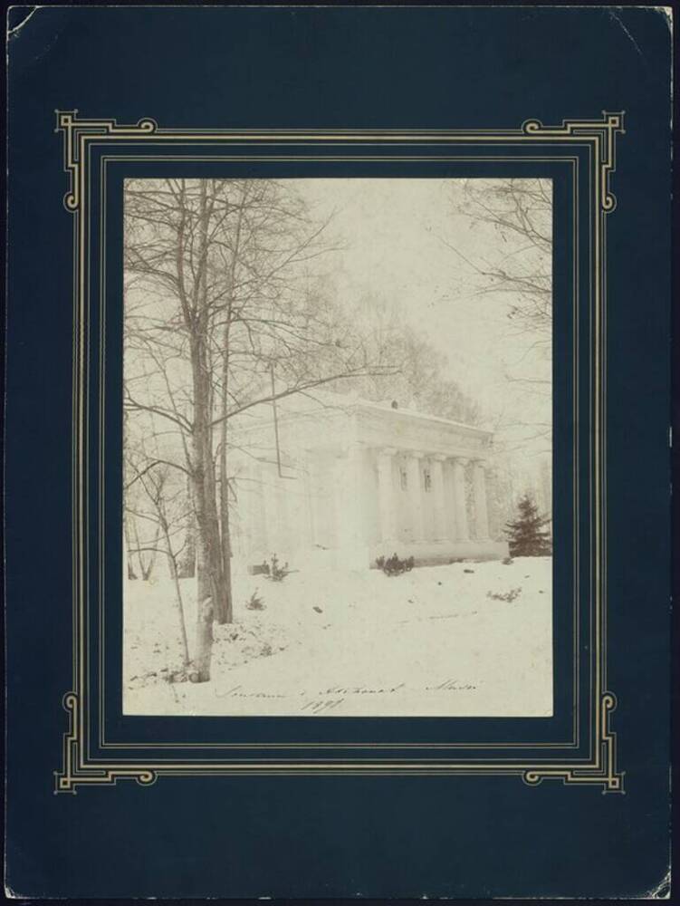 Фотография. Одноэтажное здание с колоннадой в парке зимой. Надпись по нижнему краю.