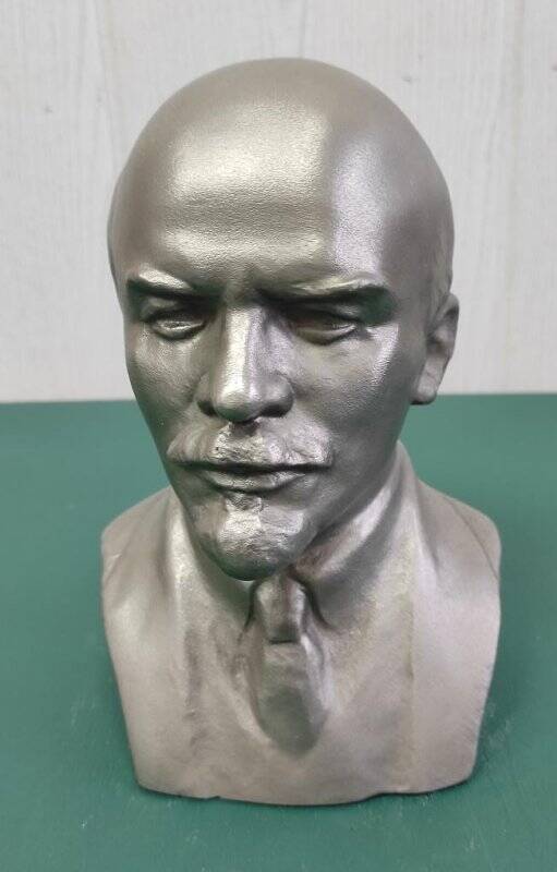 Бюст В.И. Ленина серебристого цвета литой из металла.