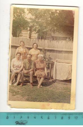 Фото групповое на фоне забора, ветки дерева, дома. Участник Великой Отечественной войны Исанчурин  Радик Курбангалеевич  с соседями во дворе.