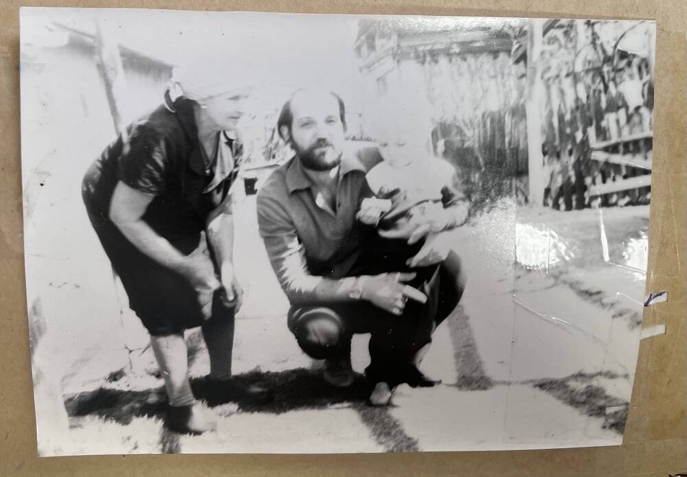 Фото групповое неизвестных с ребенком во дворе дома, 1970-1980-е годы
