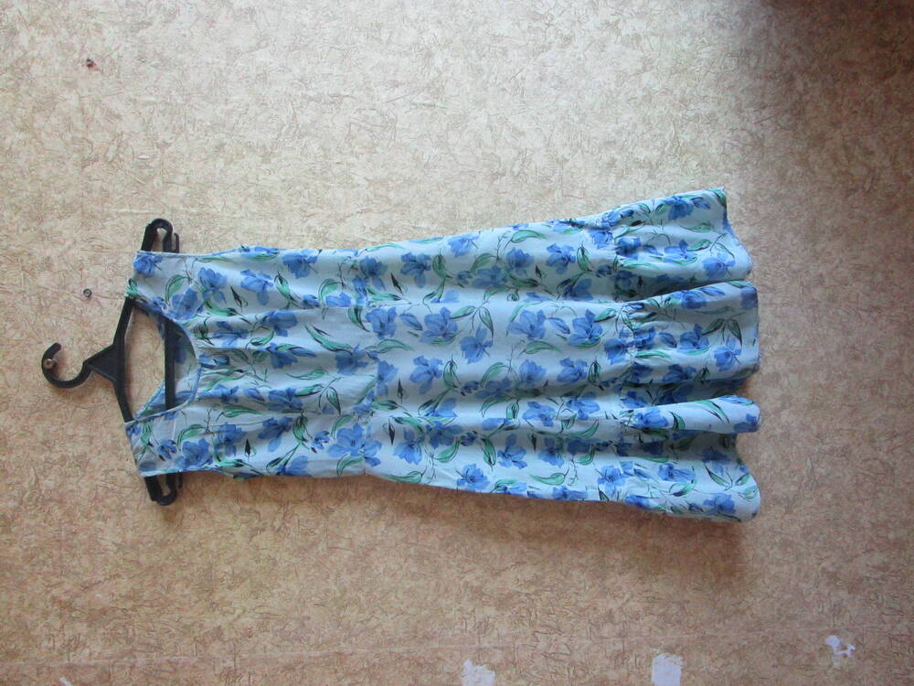 Платье женское креповое, отрезное по линии талии, шестиклинное, без рукава, серо-зеленое с цветочным принтом: сине-голубые цветы с зелеными веточками и листьями. Низ платья украшен оборкой