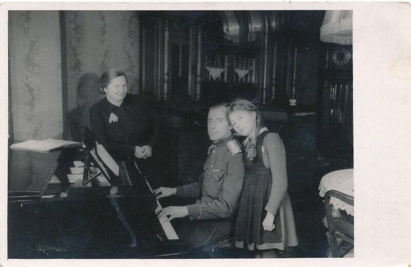 Фотография. Снимок сюжетный. Комендант города Бранденбург полковник Исаков Семен Кузьмич играет на рояле жене Анне Матвеевне и дочери Елене.