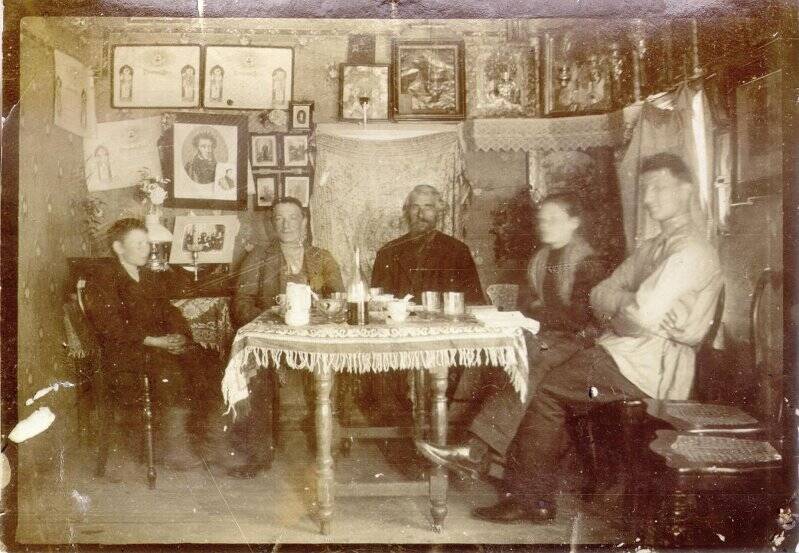 Группа людей у стола в домашней обстановке. Фотография