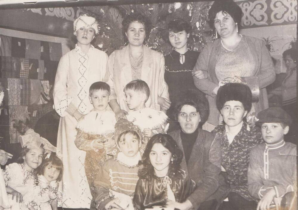 Фотография чёрно-белая групповая. Сотрудники Ромненского Дома быта с детьми на празднике Нового Года.