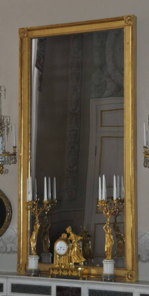 Зеркало надкаминное, в прямоугольной позолоченной раме с угловыми розетками.
