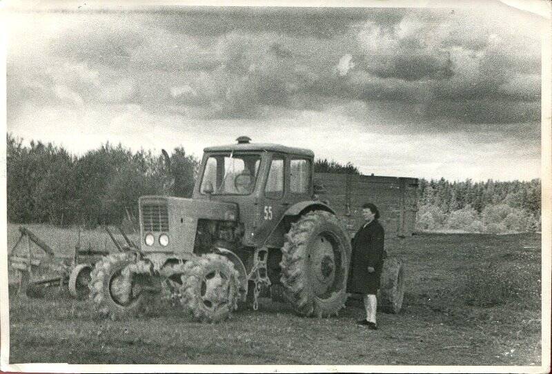Фотография ч/б. Фотография  На фоне Трактора МТЗ - 52  Киселева Валерия Николаевича стоит Киселева Г.В.