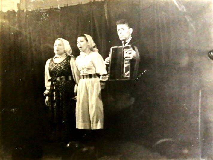 Фотография черно-белая Две женщины и гармонист выступают на сцене