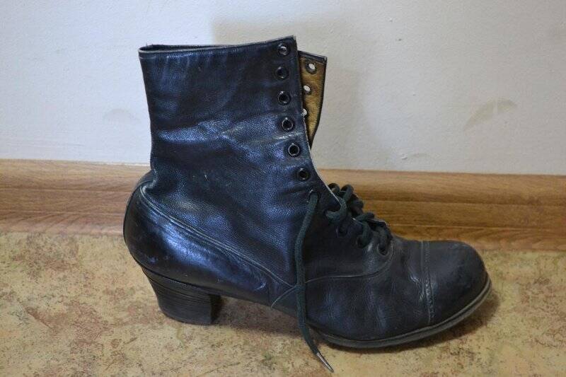 Ботинок женский, черного цвета, правой ноги. Завязывается на шнурок. Каблук широкий, слегка зауженный книзу, носок округленный, спереди 12 пар дырочек для шнурка. Приблизительно 30-х годов.