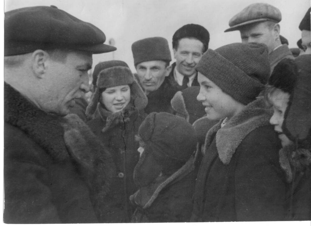 В.П. Чкалов в шубе и кепке среди земляков беседует с ребятами - школьниками. Фото Вознесенского.