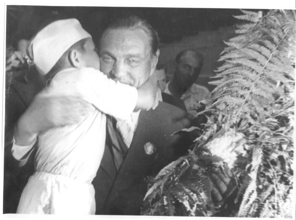 Фото. Пионер Петя Фурманов целует В. П. Чкалова на вечере стахановцев авиазавода.