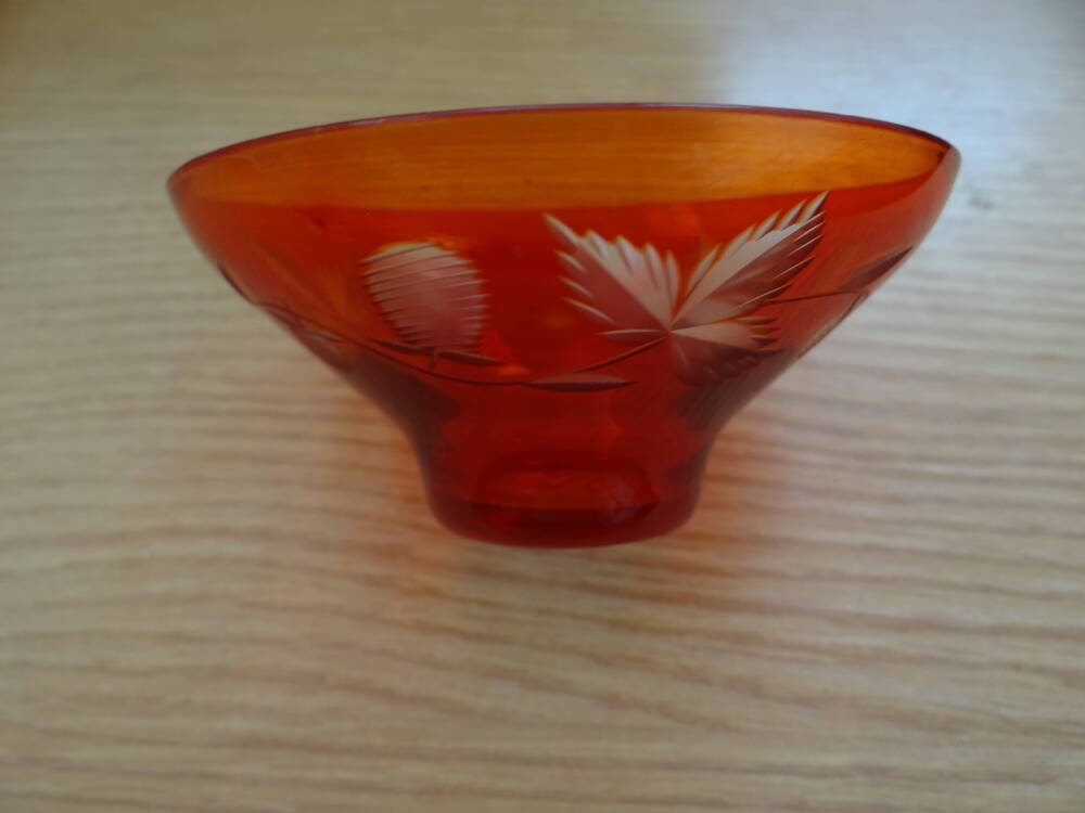 Ваза-конфетница из красного стекла с резным растительным орнаментом по внешней стороне, по форме в виде чаши с узким высоким круглым дном.