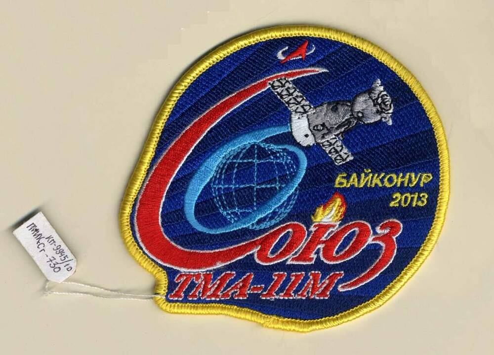 Эмблема полетная экипажа космического корабля «Союз ТМА-11 М» в составе космонавтов М. Тюрина (Россия), астронавтам Р. Мастраккио (США), К. Ваката (Япония)