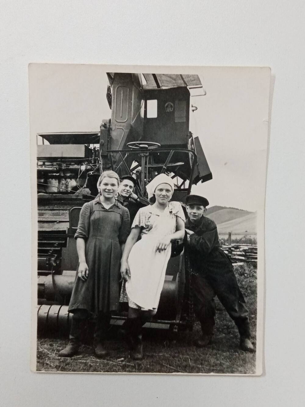 Фотография Мазуровой Клавдии Матвеевны –  первая слева, с группой молодых колхозников, сняты рядом с первым самоходным комбайном колхоза Новый путь.1957 год.