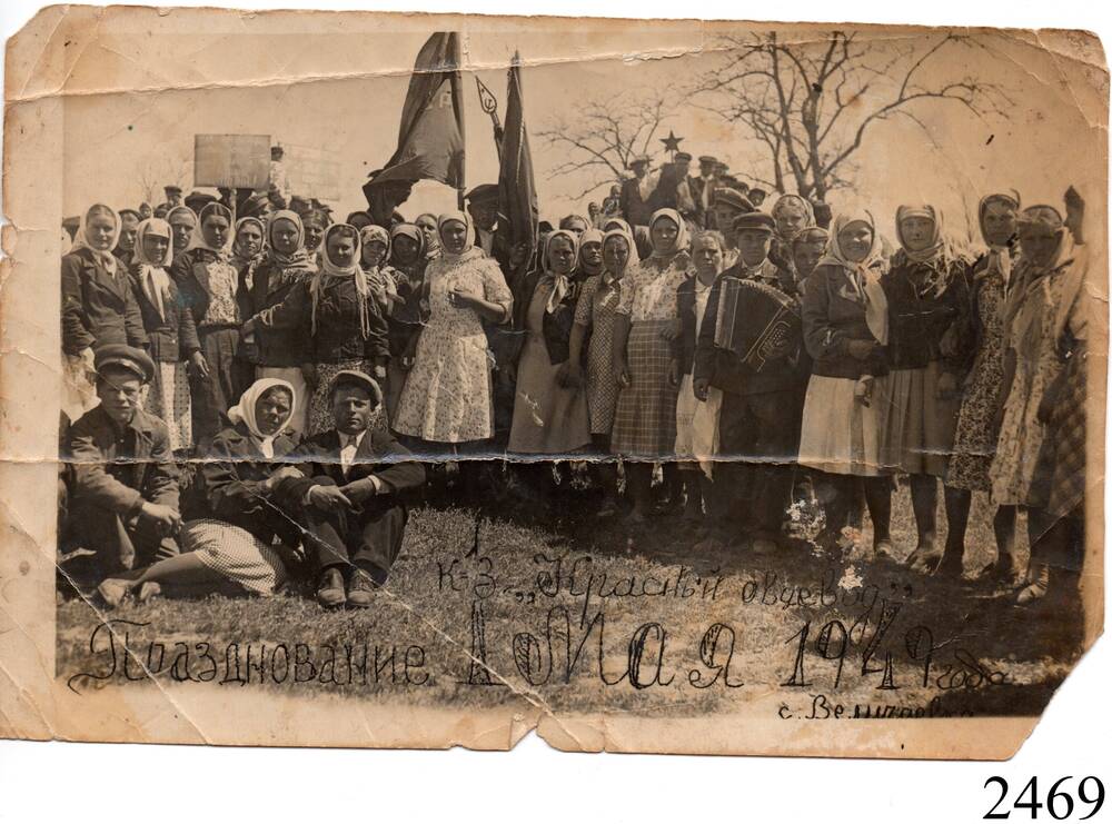 Фотография черно-белая, глянцевая,
 групповая, сюжетная, группа людей сидя и стоя, со знаменами. Внизу на фото надписи «Празднование 1 мая, 1949 года», « к-з «Красный овцевод», «с. Величаевское». 
  с. Величаевское