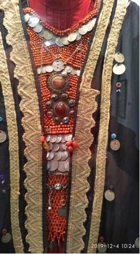 Нагрудник (селтэр) нагрудное украшение башкирской женщины из коралловых бус, серебряных монет, серебряной цепочки, серебряных подвесок, брошек, пуговиц, серебряного бубенчика нашитых на ткань