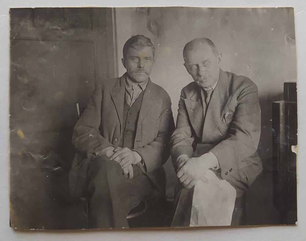 Фотография черно-белая. А.П. Бибик сидит рядом с неизвестным человеком.