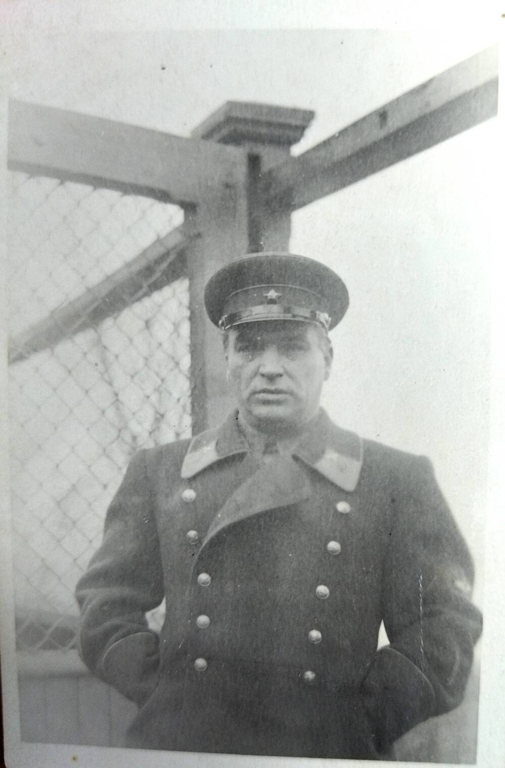 Фотография. В.П.Чкалов в форме комбрига стоит у открытой калитки сада на родине в последний приезд, 30.11.1938 год.