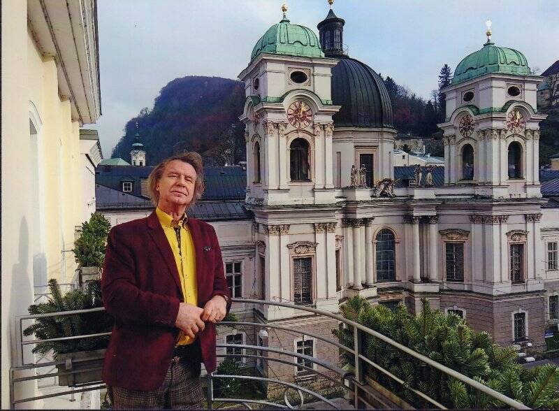 Фотография цветная. А.М. Шилов на балконе на фоне церкви Св. Троицы в Зальцбурге