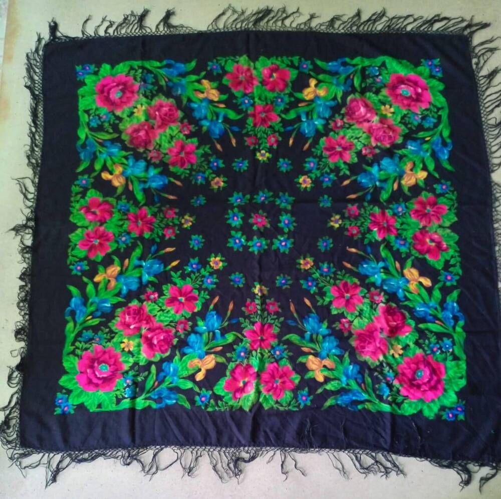 Платок квадратный черный с кистями по краям, с цветочным орнаментом в виде розовых роз, синих гладиолусов, зеленых листьев.