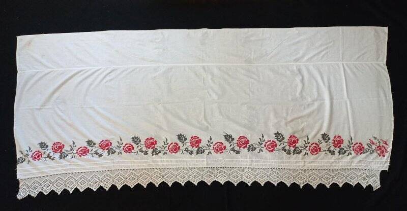 Накидка из белой ткани для краев кровати с вышивками цветов розы красного цвета и зелеными листьями.