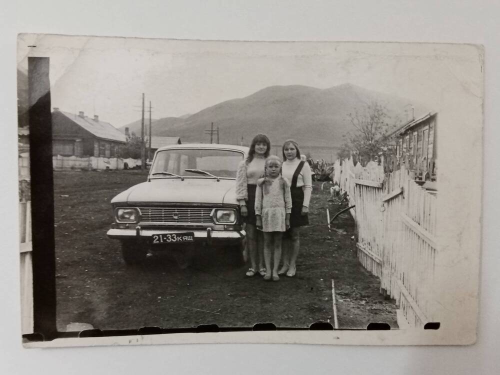 Фотография сестёр Торгашиных  у своего дома по улице Новобольничной в селе Копьёво рядом с  легковым автомобилем Москвич-412. Начало 1970-х годов