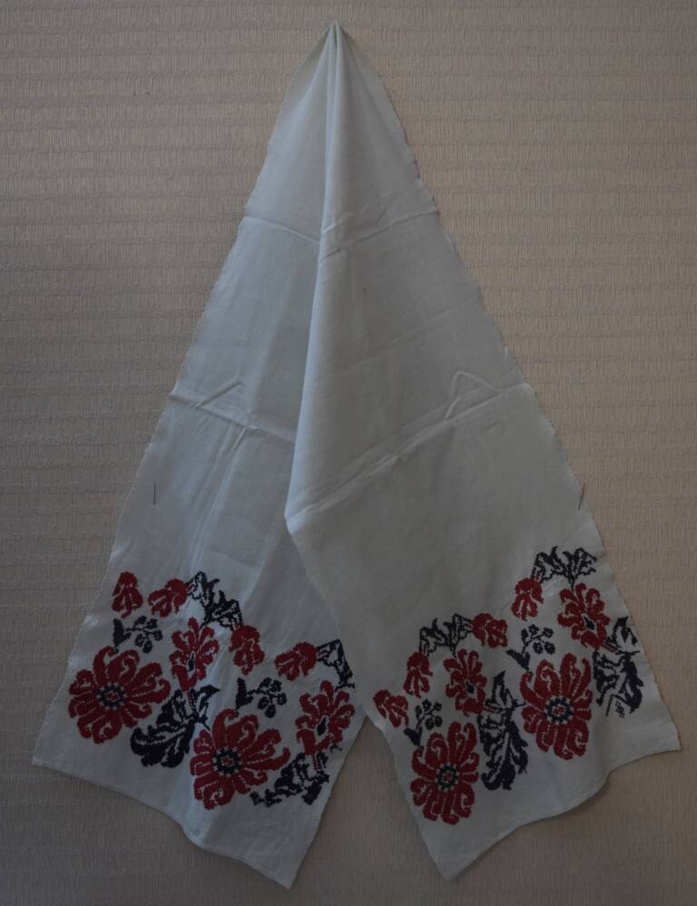 Рушник из белого полотна, ткань хлопчатобумажная, по краям вышиты цветы красными нитками,  черными нитками - узоры.